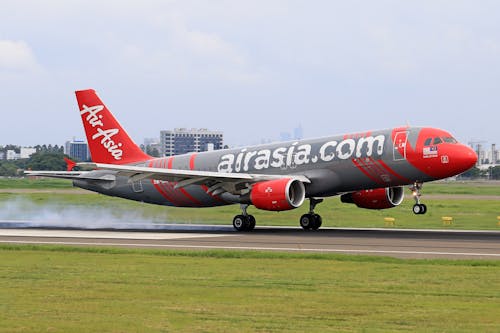 A red and gray airplane taking off from an airport runway