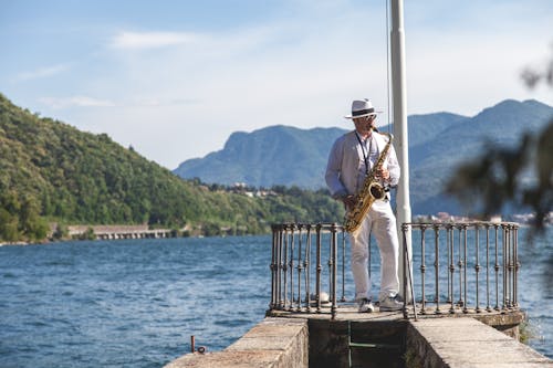 Uomo Che Suona Il Corno Francese Sul Dock