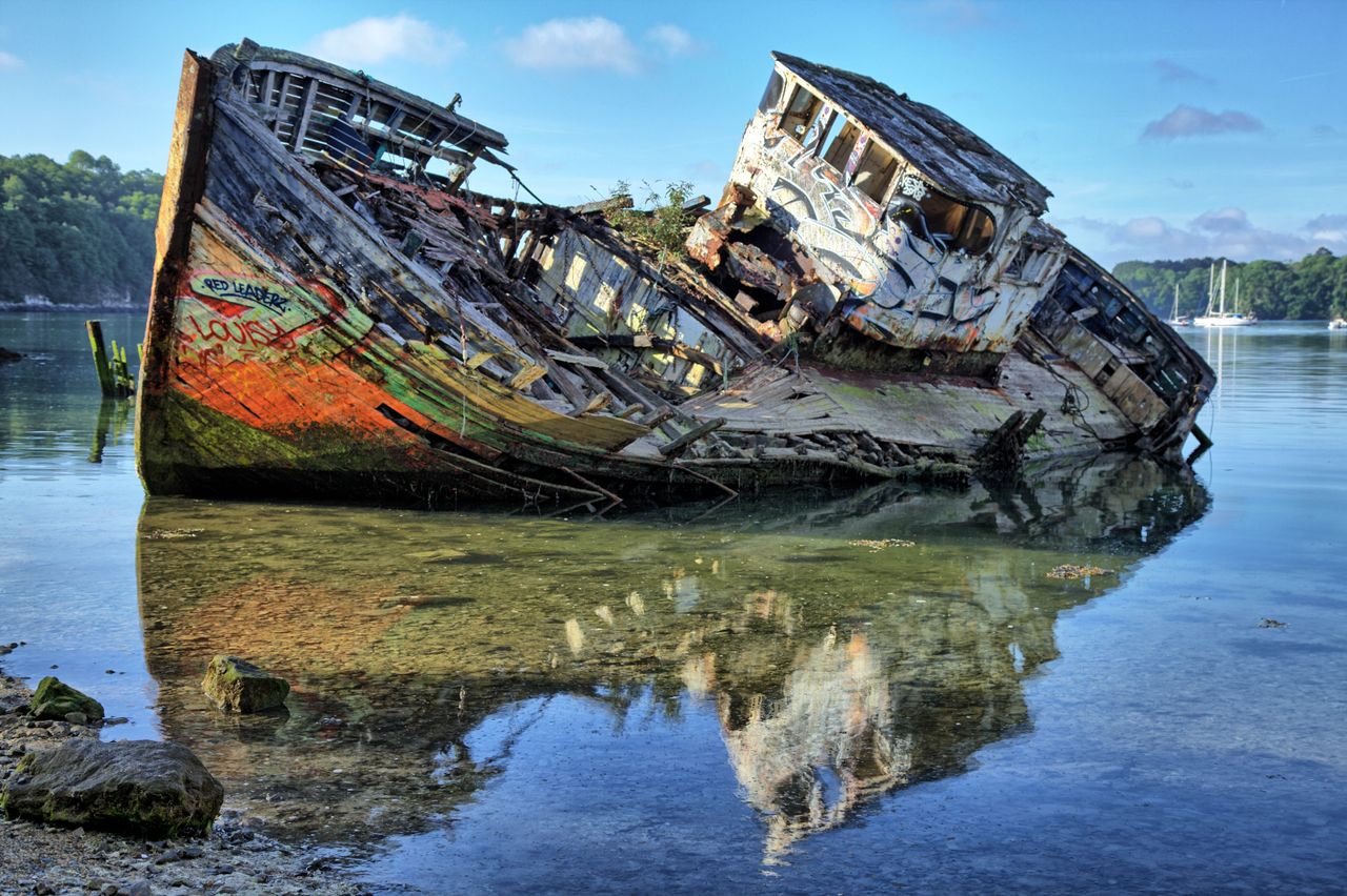 a colorful graffiti covered shipwreck on the serene waters of saint ma