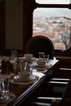 Luxurious dining setup with cityscape through window.