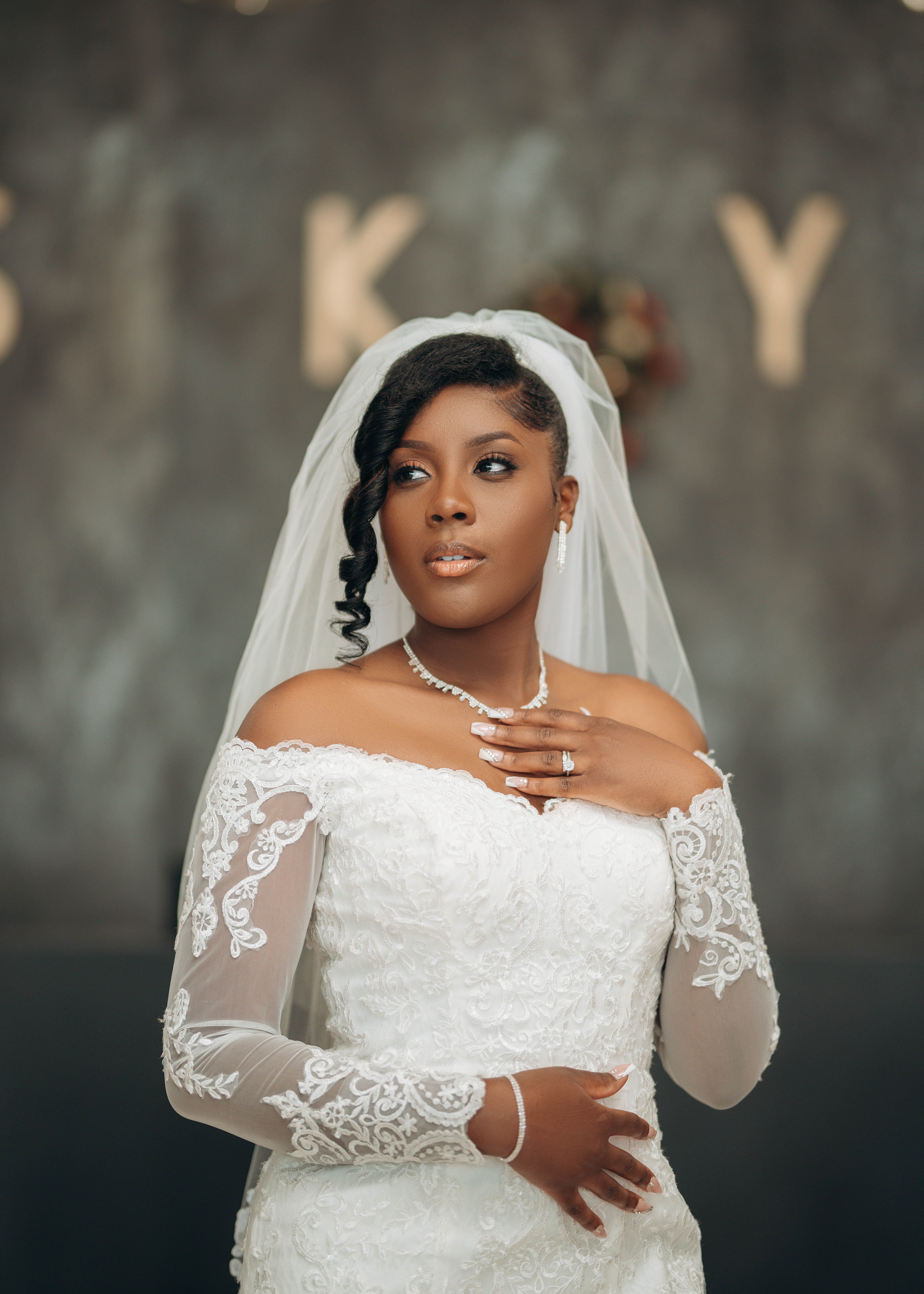 A beautiful African bride in a white lace wedding dress with a veil, looking graceful and elegant.