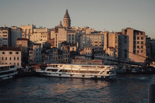 Serene cityscape of Istanbul with Galata Tower at golden hour, capturing historic architecture and Bosphorus ferries.