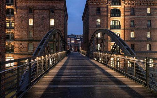 Free Kibbelsteg Bridge in Hamburg's Speicherstadt lit up at night, showcasing iconic architecture. Stock Photo