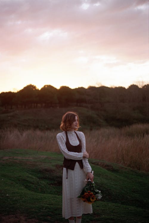 Short Haired Girl with a Bouquet Of Roses Standing In the Fields