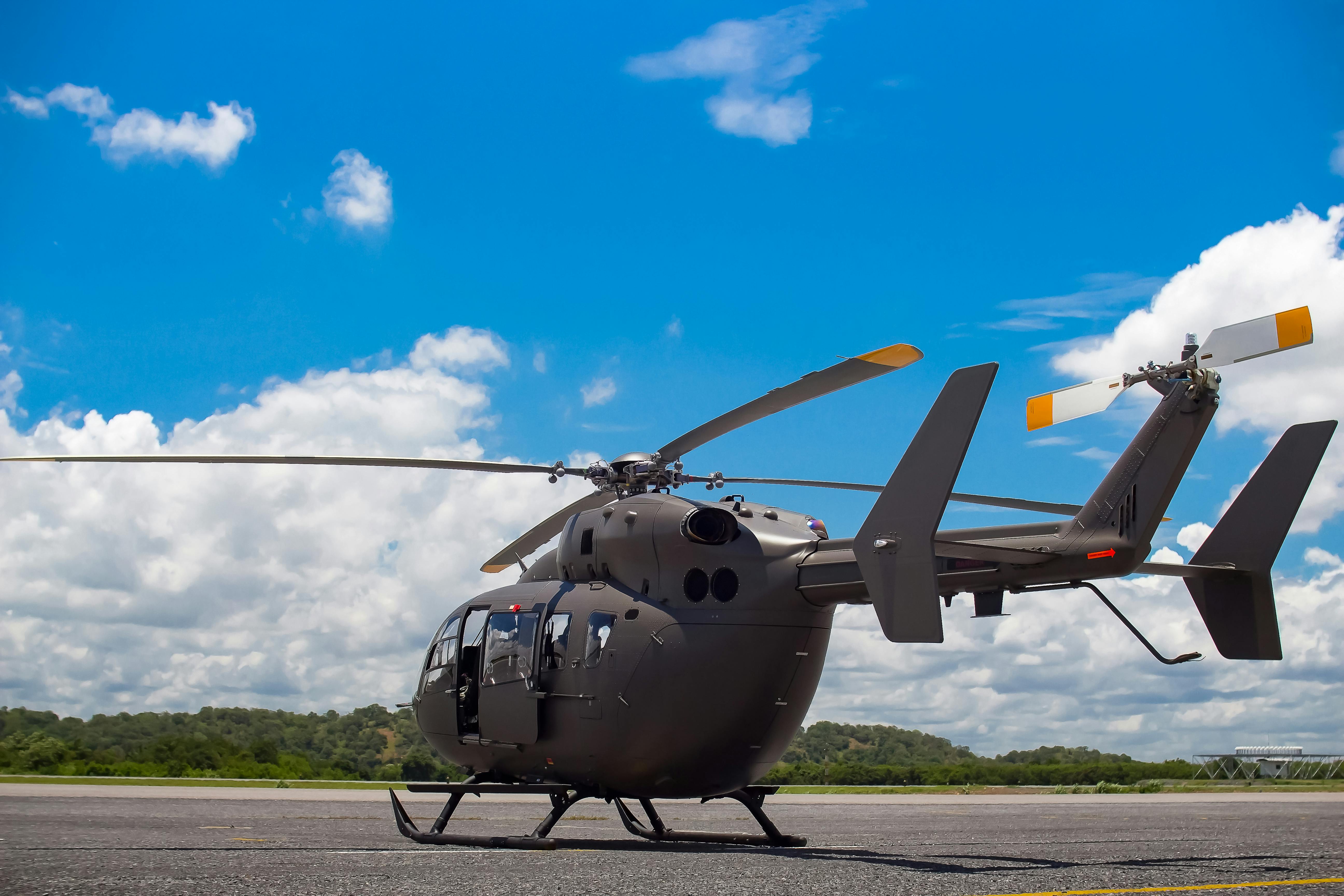 Gray Helicopter on Gray Concrete Pavement Under Blue Sky