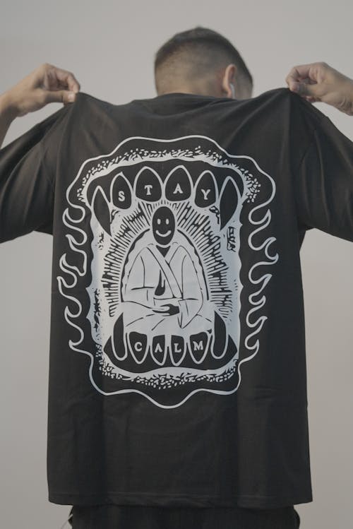 Man Shows Print of Sitting Buddhist Monk on back of his T-shirt