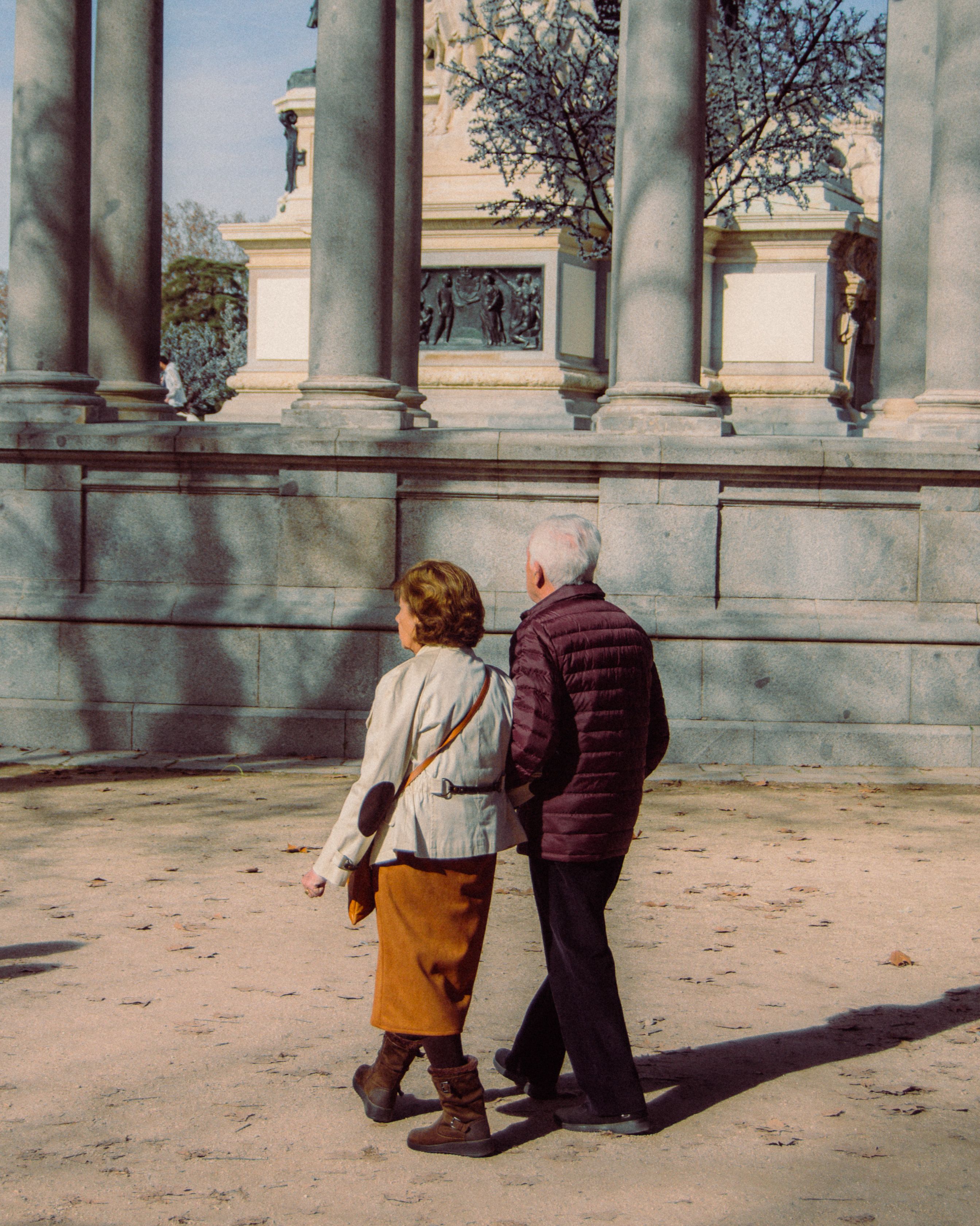 An older couple walking together outdoors, unhurried and at ease.