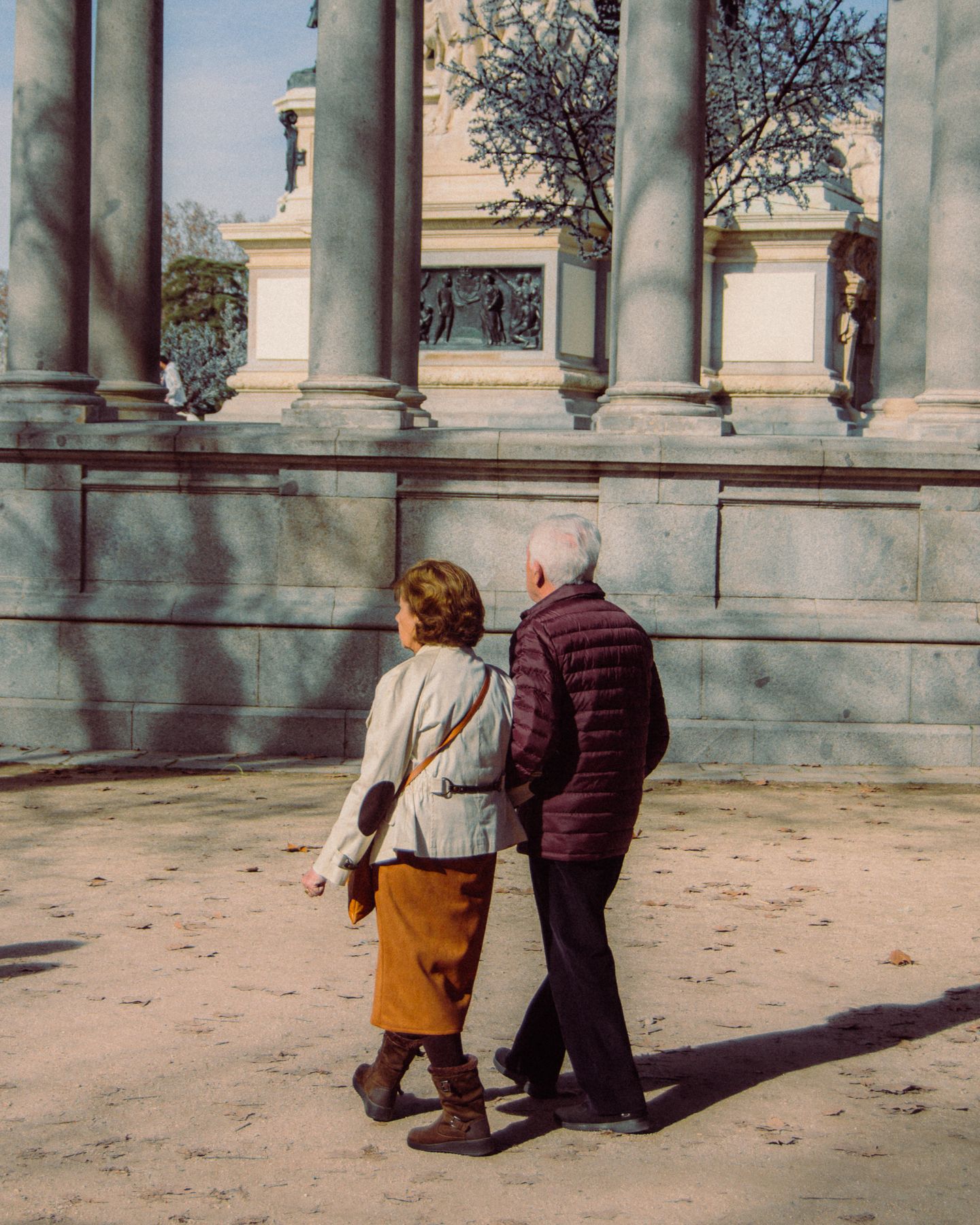 An older couple walking together outdoors, unhurried and at ease.