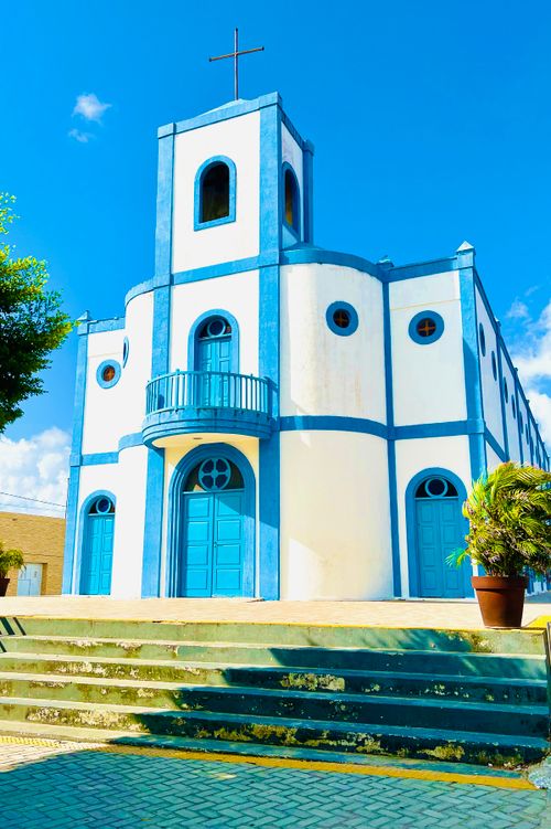 Free Beautiful church facade with blue and white design against a clear sky, featuring stairs and plant decor. Stock Photo