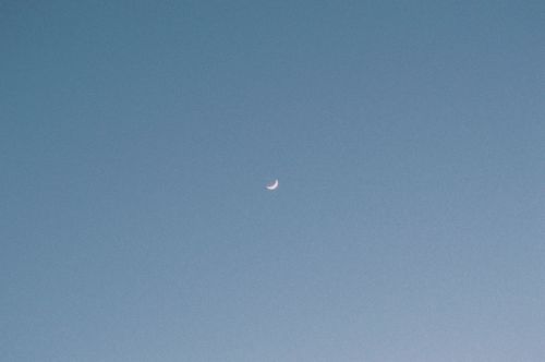 Free A tranquil view of the crescent moon against a clear twilight sky, radiating calmness. Stock Photo