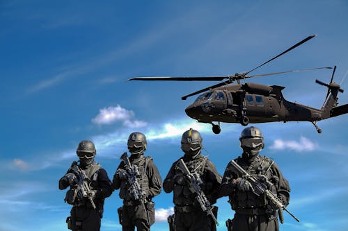 Empat Prajurit Membawa Senapan Di Dekat Helikopter Di Bawah Langit Biru