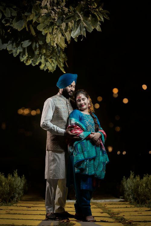 Free Charming Indian couple in traditional attire posing outdoors at night in Chandigarh. Stock Photo