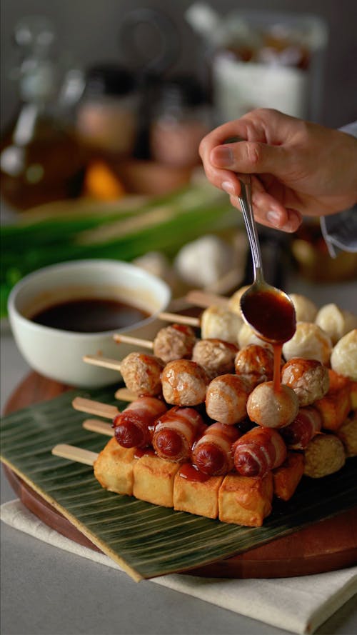 A person is holding a spoon over a plate of food