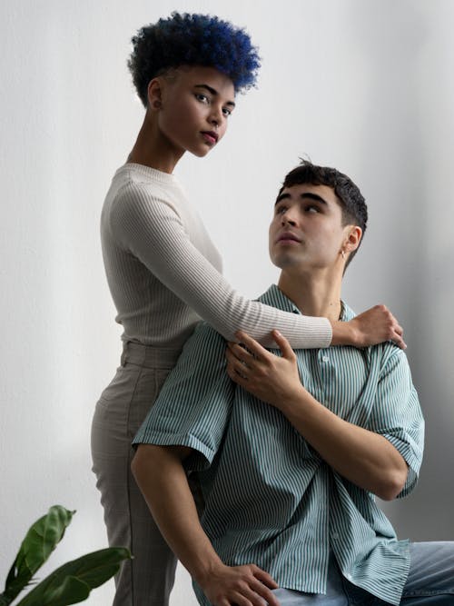 A man and woman with blue hair sitting on a couch