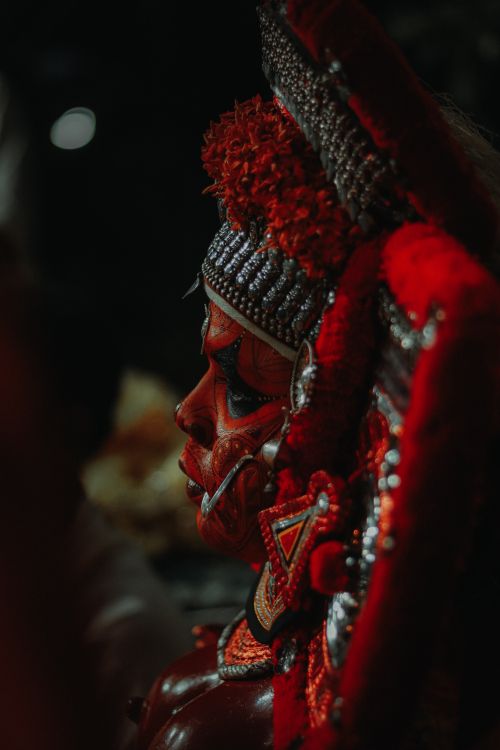 Free Close-up of a performer in elaborate Theyyam makeup and costume during a ritual. Stock Photo