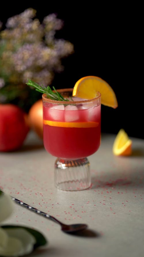 A cocktail with orange slices and a garnish