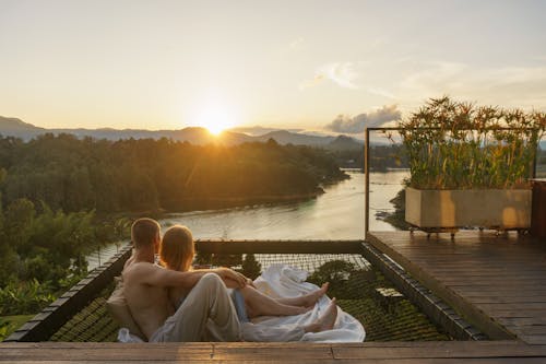 Couple Lying on a Terrace and Looking at Beautiful Landscape at Sunset 