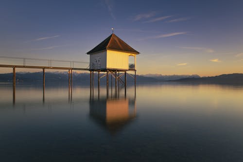 A small wooden house on a pier at sunset