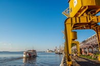 港口景观充满活力，船只、起重机与享受晴朗天气的人们构成了一幅生动的画面