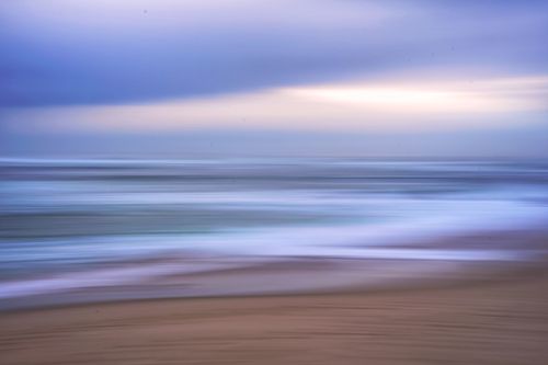 Free Serene beach scene with ocean waves and sky in motion blur captured during sunset. Stock Photo