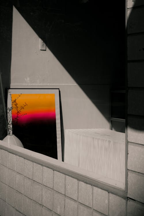A black and white photo of a window with a sunset