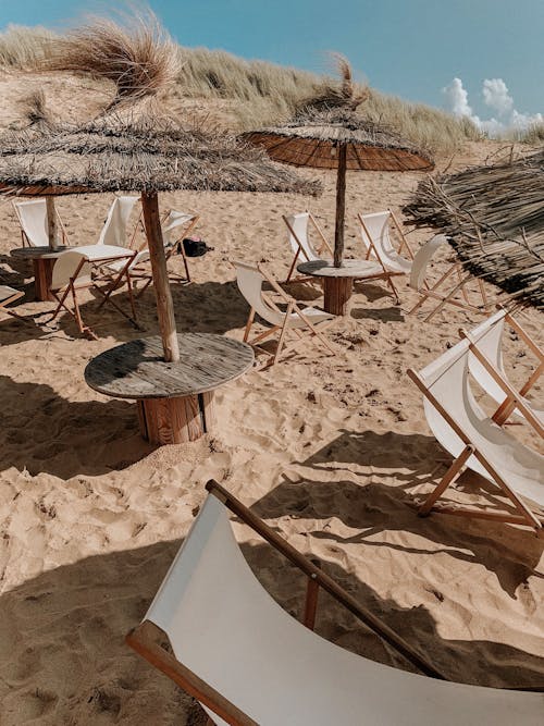 Loungers under Thatched Sunshades on Beach