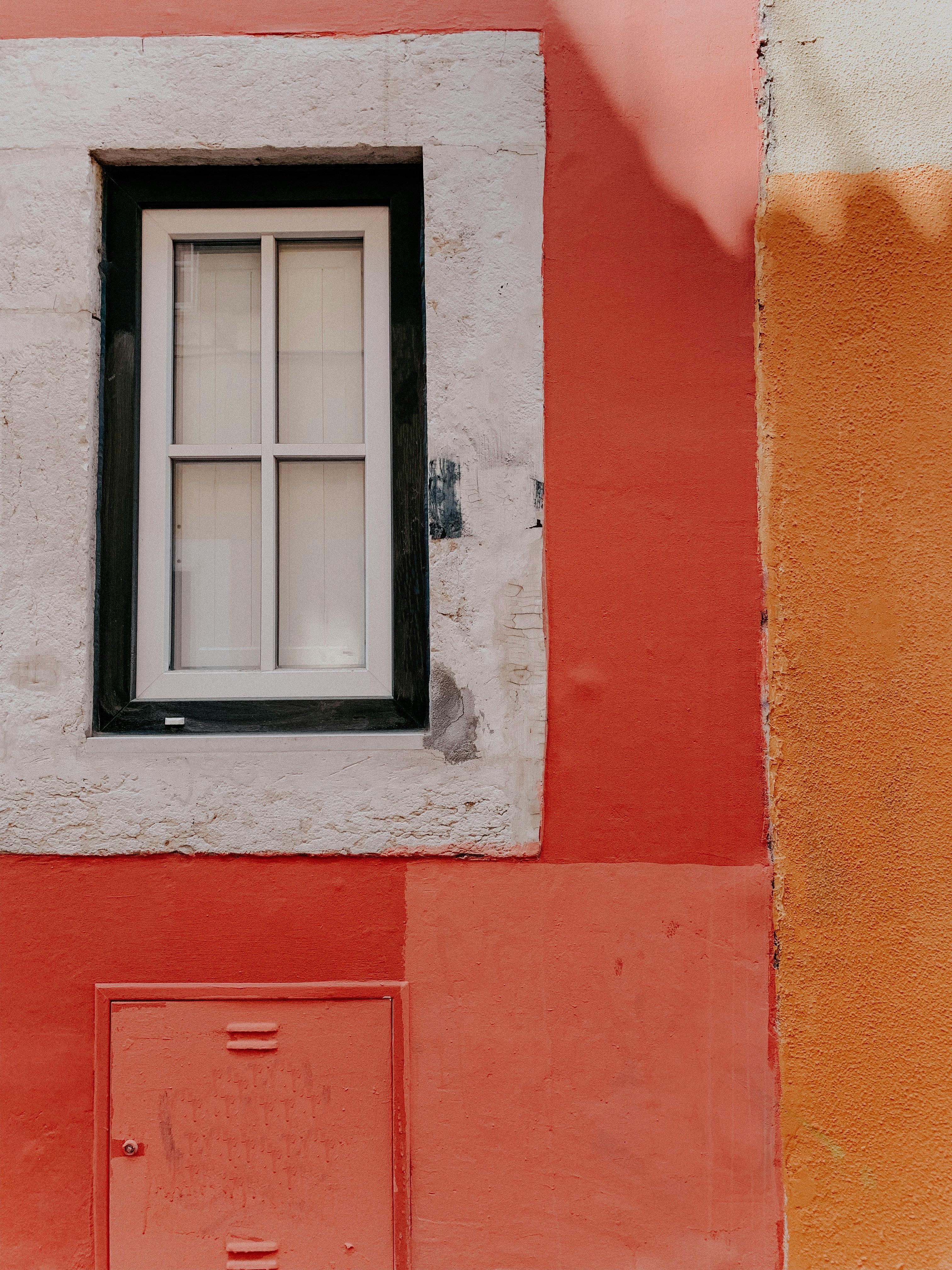 Close-up of a vivid building facade with a stone-framed window.
