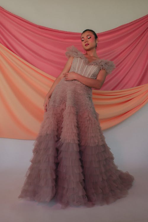 A woman in a pink gown posing for the camera