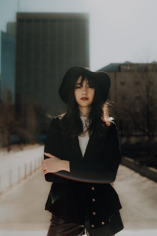 A woman in a black hat and leather jacket