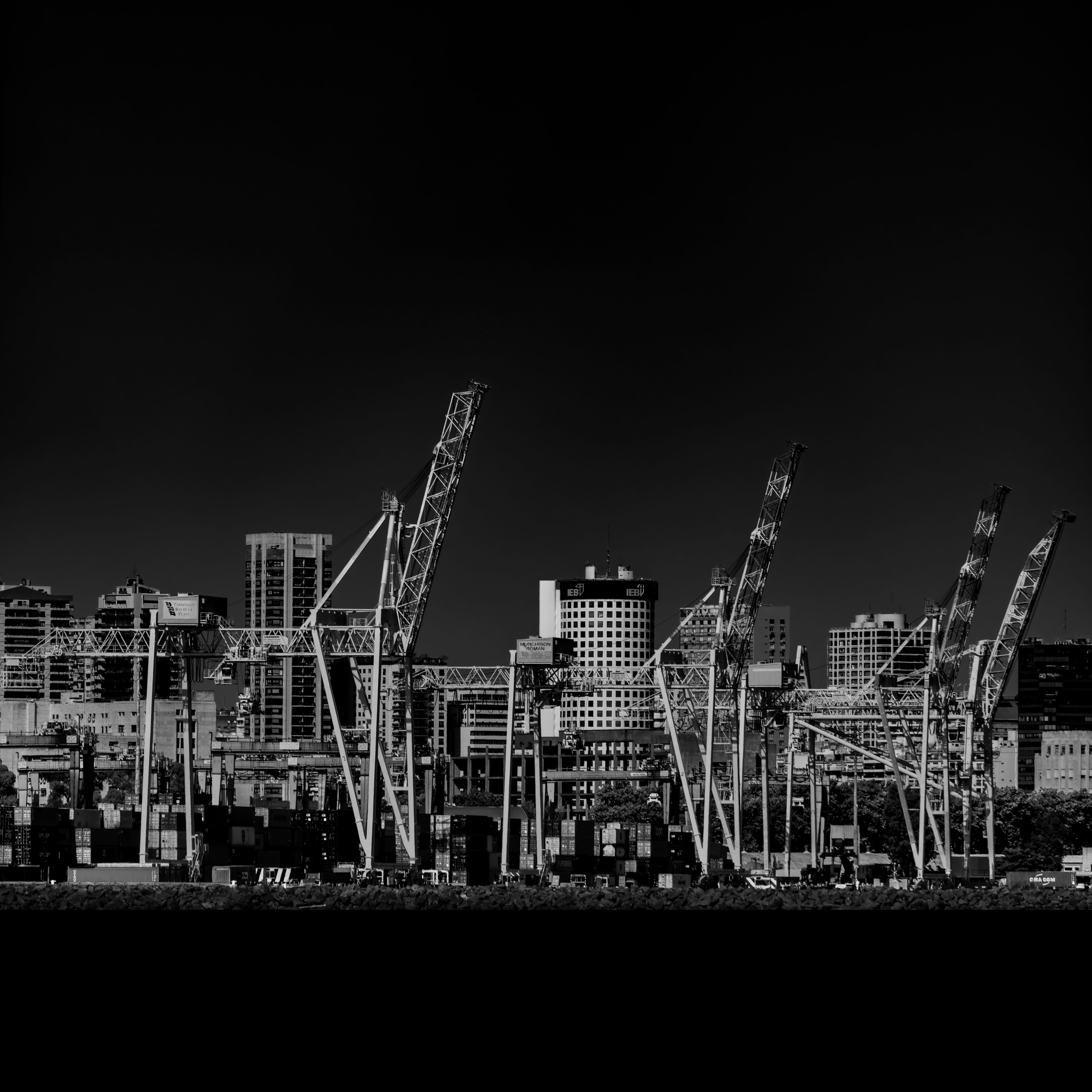 Harbor cranes above an urban waterfront — photo by Pablo Picardi Photography on Pexels