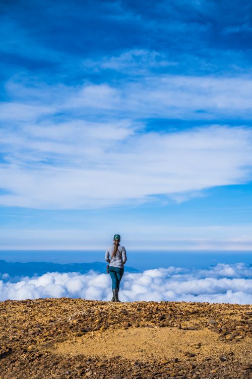 Free Woman standing on a mountainous peak in Huila, Colombia, gazing at a vast cloudy sky. Stock Photo
