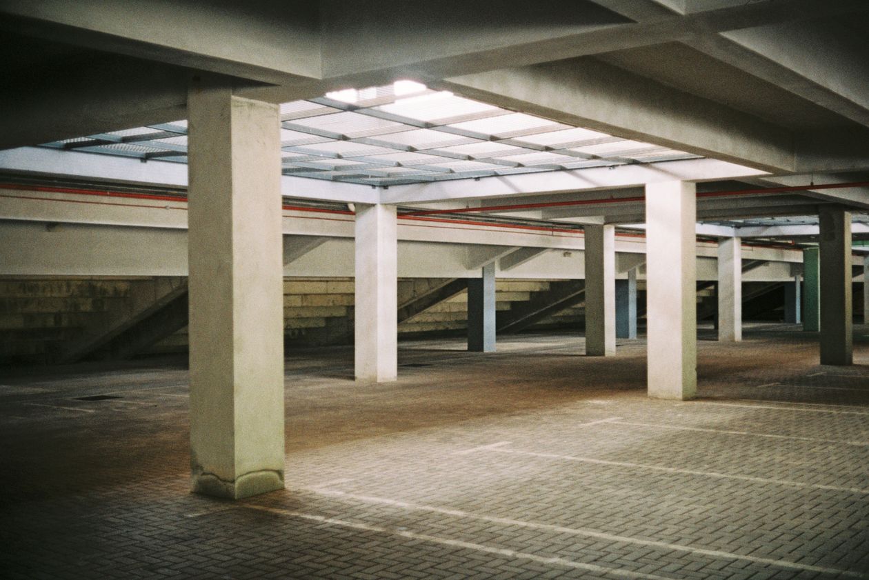 Étage vide d'un stationnement intérieur avec colonnes de béton et puits de lumière