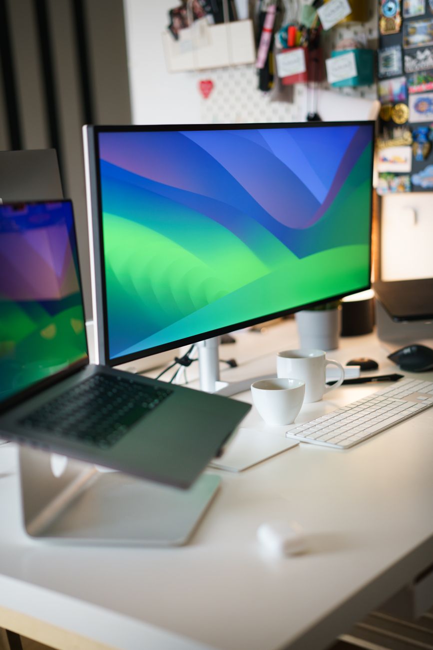 A sleek and contemporary office setup featuring a laptop and monitor on a desk, ideal for tech-focused environments.