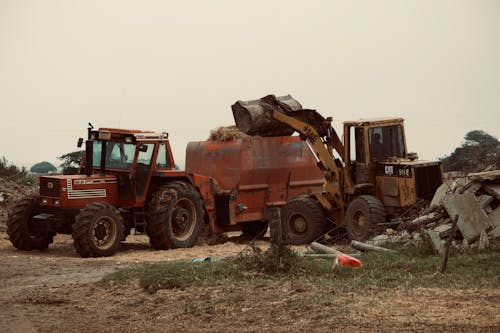 Digger Shoveling Hay to a Tractor