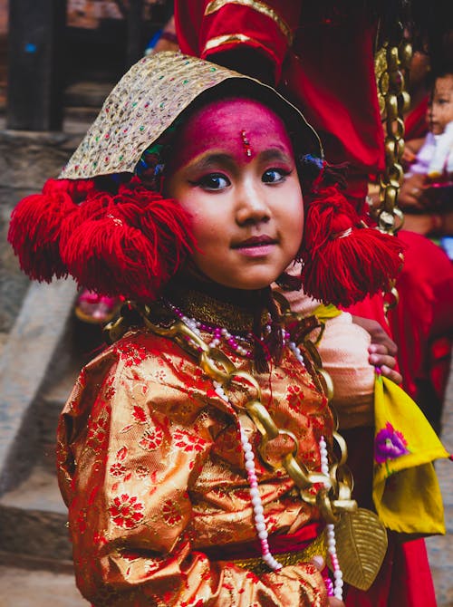 A young girl dressed in traditional clothing and headdress