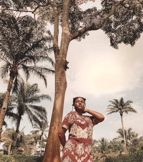 Woman in Traditional Clothing Standing by Tree