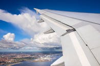 从飞机窗户俯瞰，城市景观与云层尽收眼底