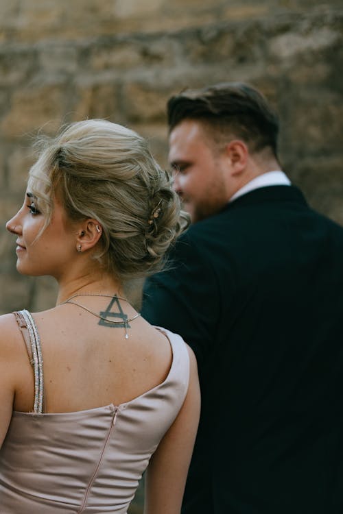 A woman with a tattoo on her back looking at a man