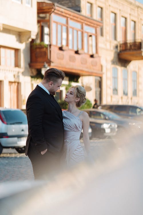 Couple in Dress and Suit Standing on Street