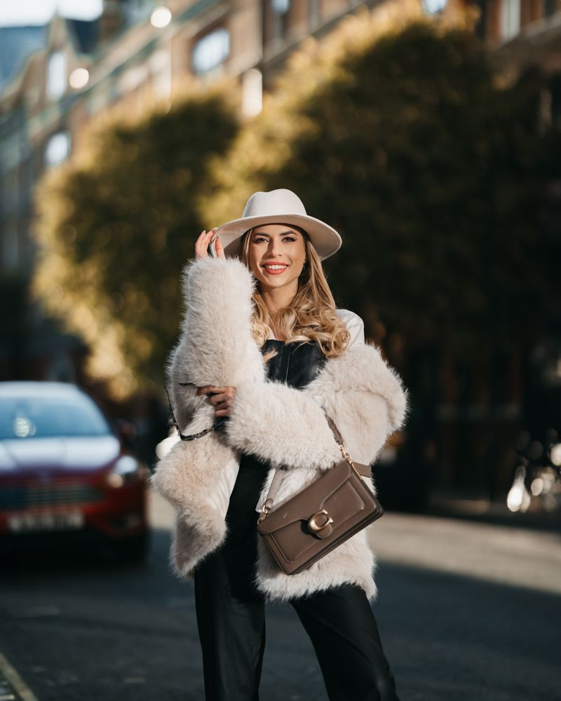 Blonde woman in fur coat and hat on a street