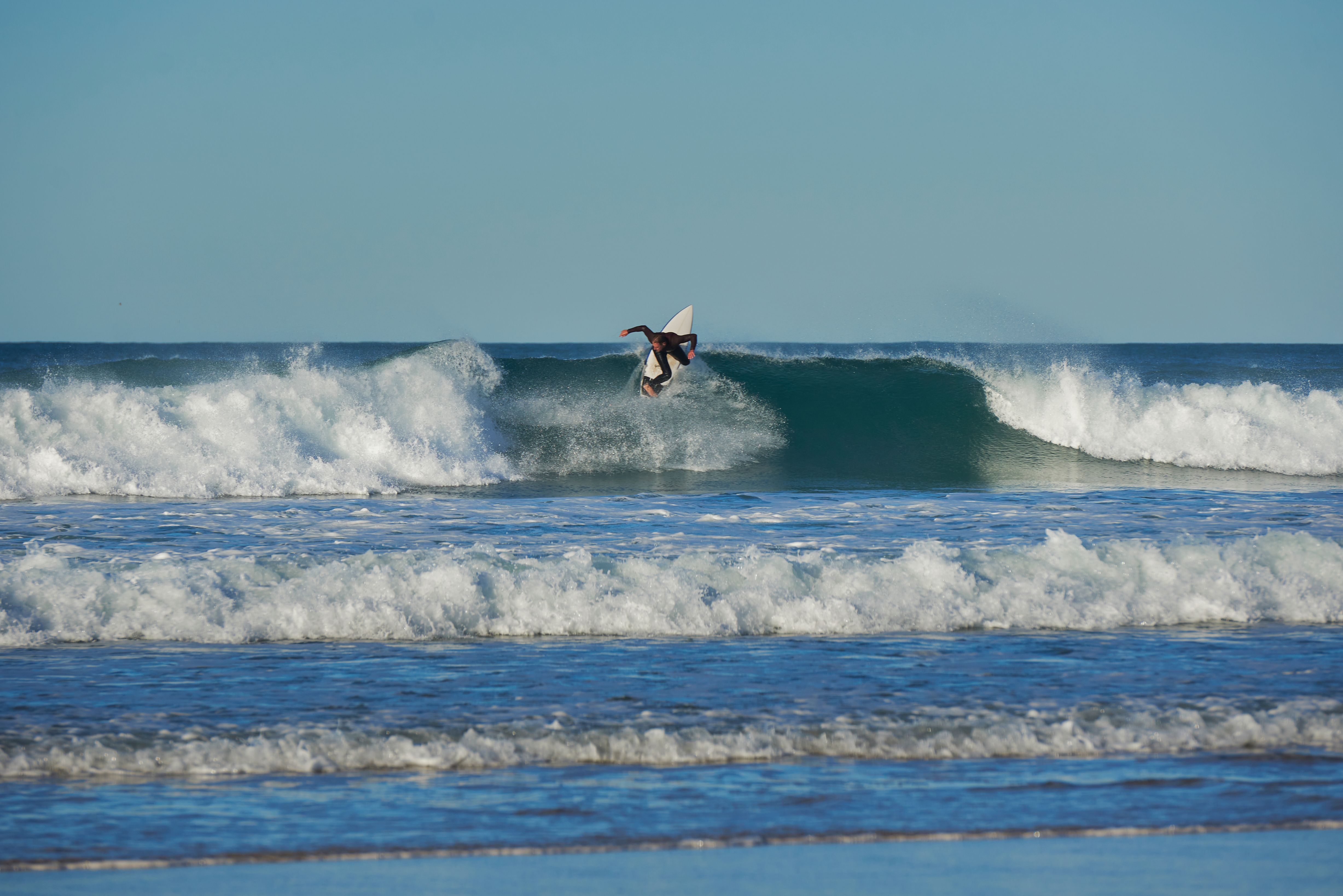 Dynamic aerial maneuver by surfer on beach waves