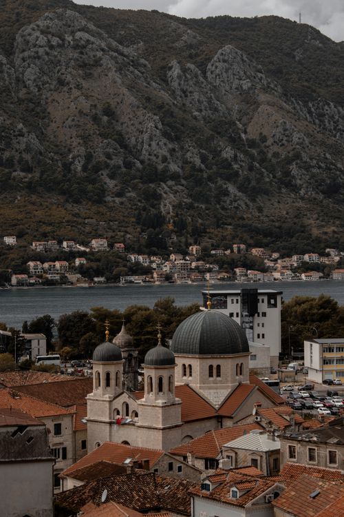 Free Scenic view of Old Town Kotor with a church and mountains, highlighting historic architecture by the bay. Stock Photo