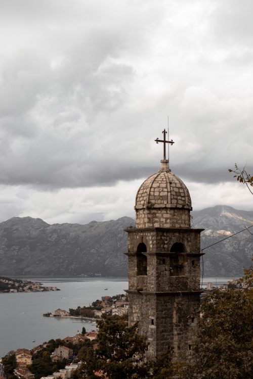 Free Stunning view of a church tower with the Bay of Kotor in the backdrop, under dramatic skies. Stock Photo