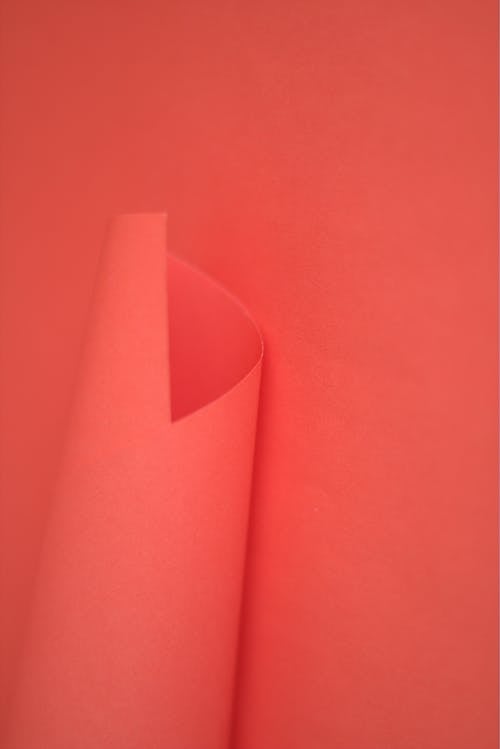 A close up of a red paper with a hole in it