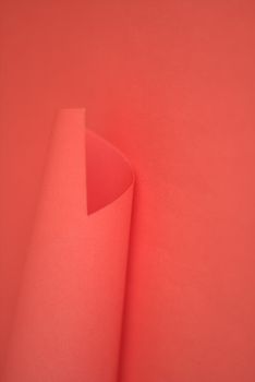 Minimalist red paper background featuring a subtle curved fold, perfect for design projects.