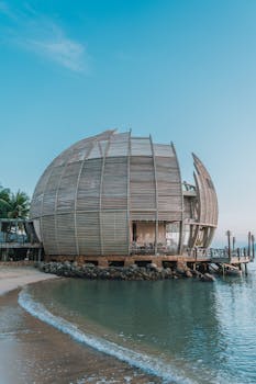 Unique architectural building on a serene beachfront at sunrise, offering a luxury escape.