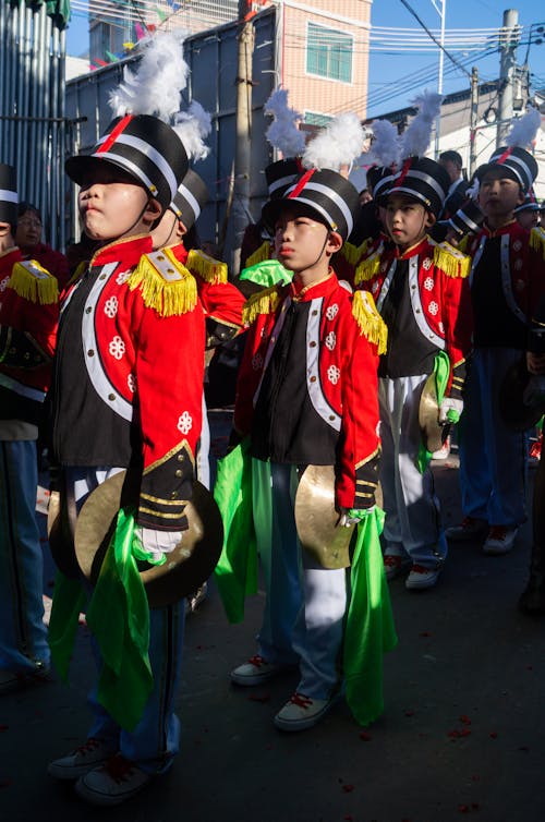 A group of children in uniform marching down the street