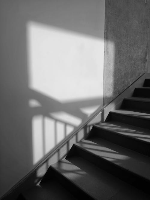 A black and white photo of stairs and shadow