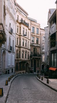 Explore a quaint cobblestone street lined with historic urban architecture.