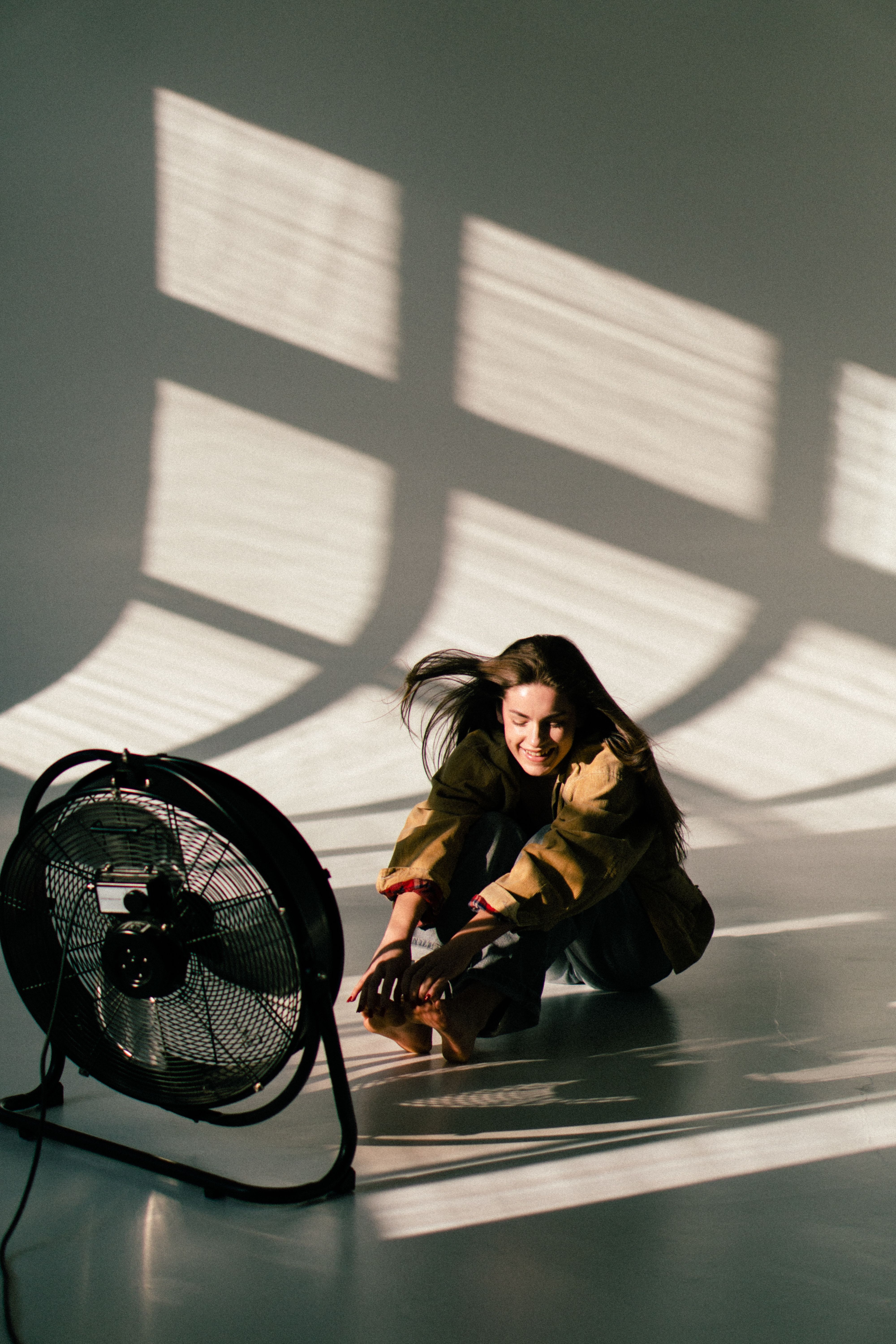 A Model Sitting in Front of a Fan in a Studio during a Photoshoot ...